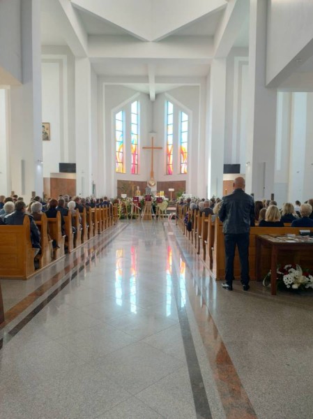 Jasne, wysokie wnętrze świątyni w Strzyżowie wypełnione uczestnikami pogrzebu ppłk. Tadeusza Lutaka "Pancerza". Wypolerowana posadzka odbija światło witraży z prezbiterium, w którym ustawiono trumnę w asyście wieńców pogrzebowych.