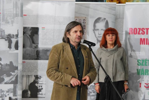 Przemówienie dyrektora Festiwalu Filmowego NNW Arkadiusza Gołębiewskiego podczas krakowskiej retrospektywy. Wystąpienie przy mikrofonie odbywa się na tle plansz wystawy historycznej poświęconej wydarzeniom 1956 roku.