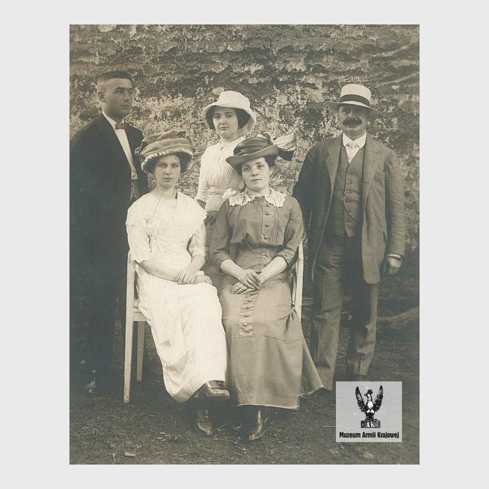 Pięć osób na tle muru